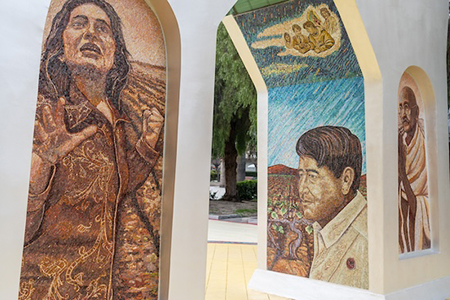 on campus mural in arches, showing fieldworkers and activists