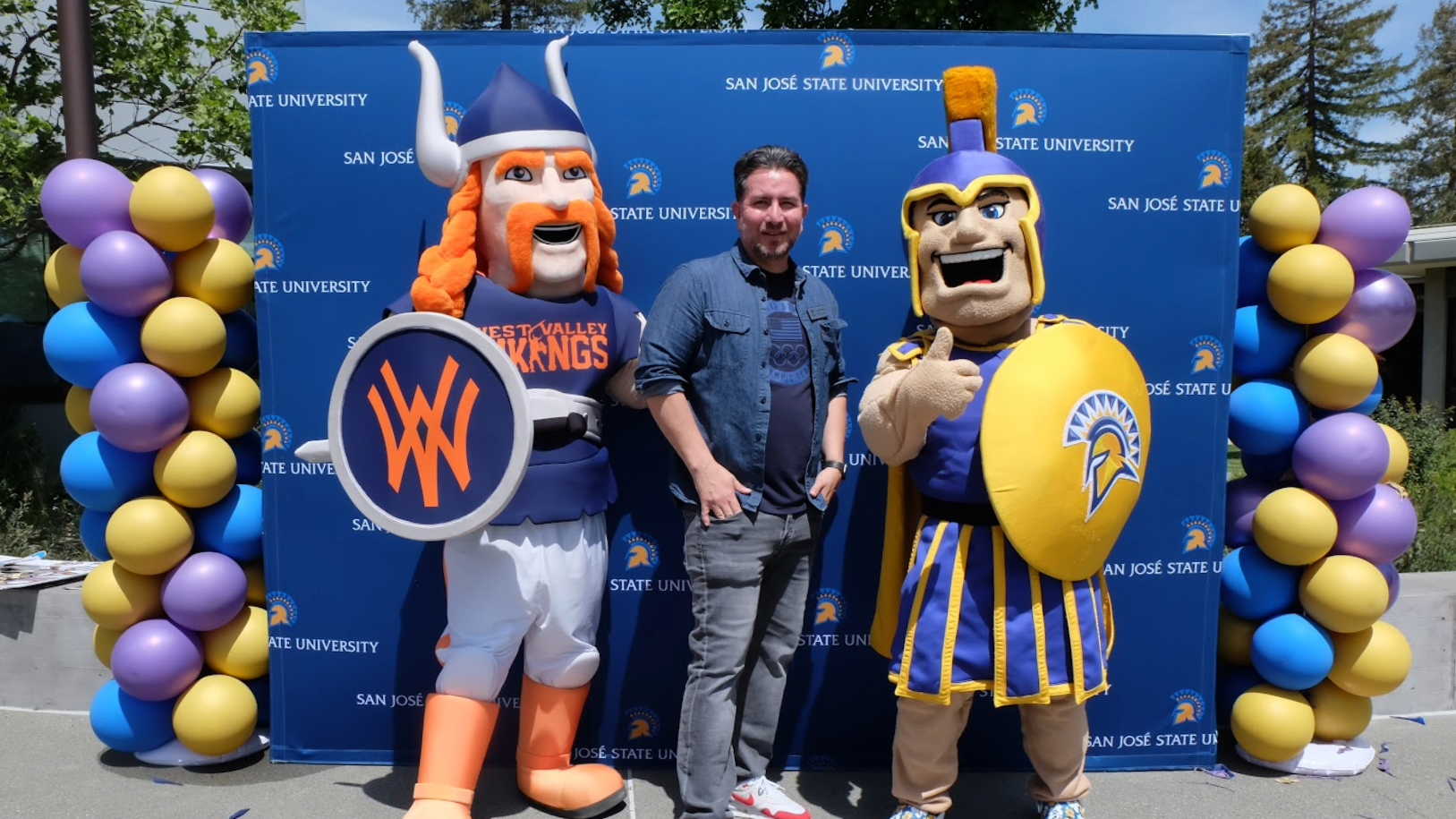 Sammy Spartan and Vic the Viking pose with a community college staff member