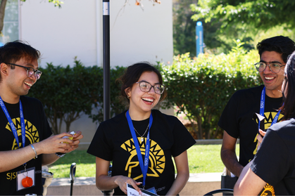 Three team members laughing at a campus event